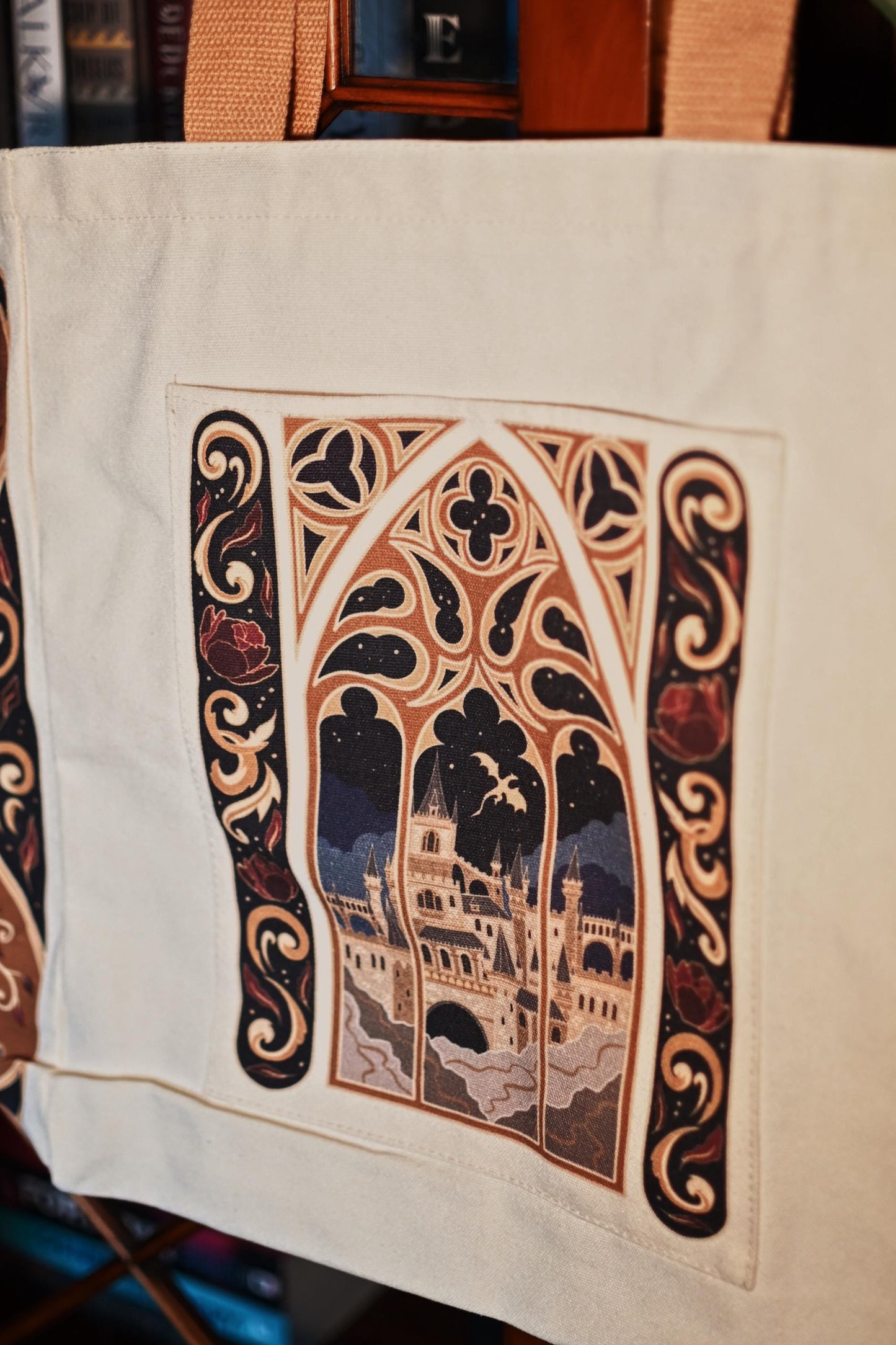 Close up image of the fantasy book bag, showcasing the window design looking out onto a window with a view of a castle and dragon flying in the sky.