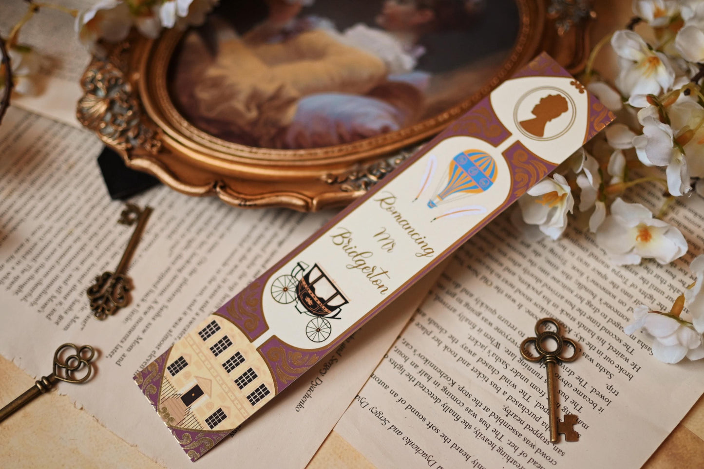 Inspired by Romancing Mr Bridgerton, No One Designs bookspine bookmark features the bookmark against a background of bookpages. The bookmark includes illustrations of the hot air ballon, carriage, bridgerton house and gold foil detailing.