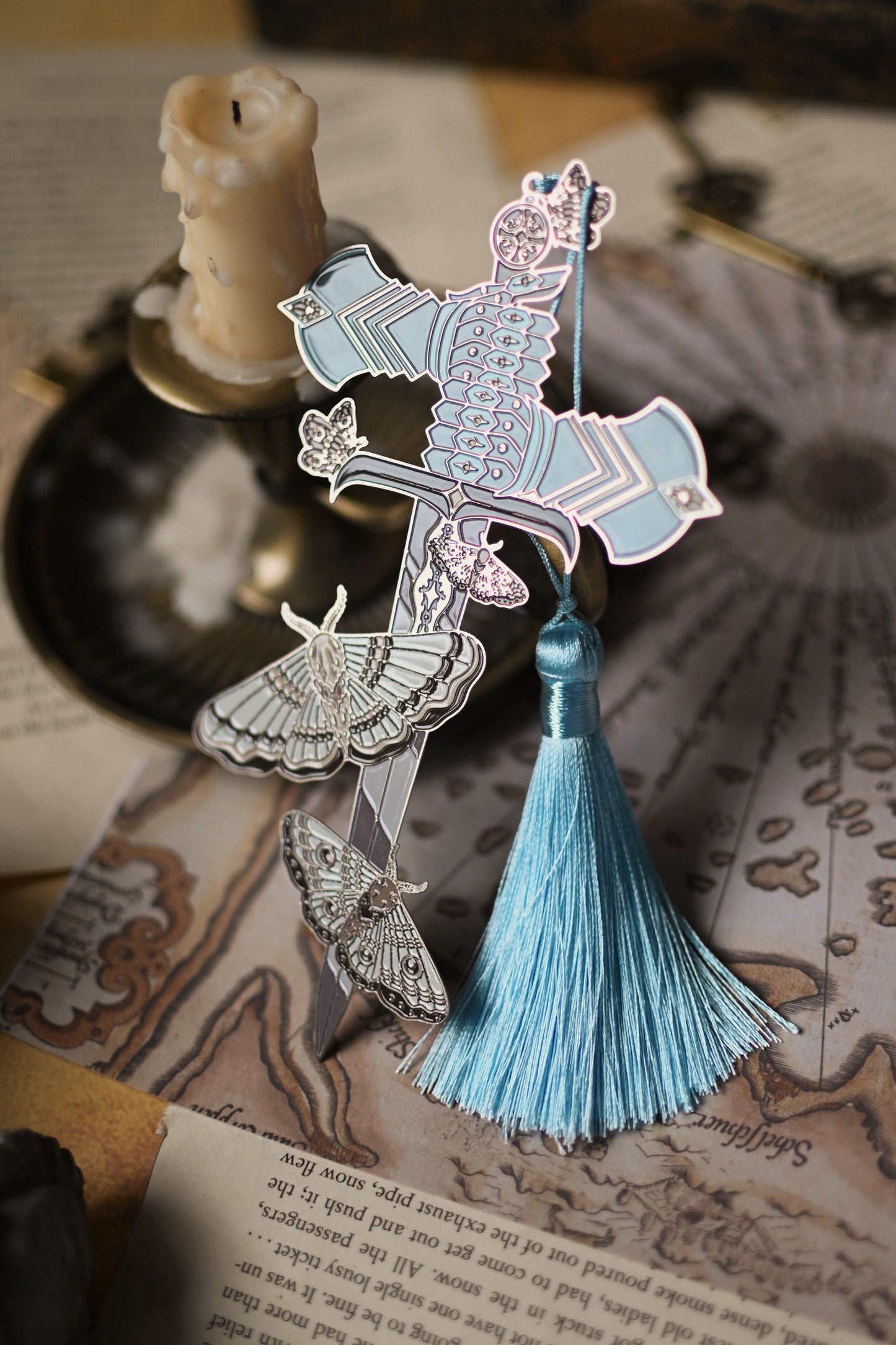 The Knight and the Moth decorative bookmark with tassel on an open book.