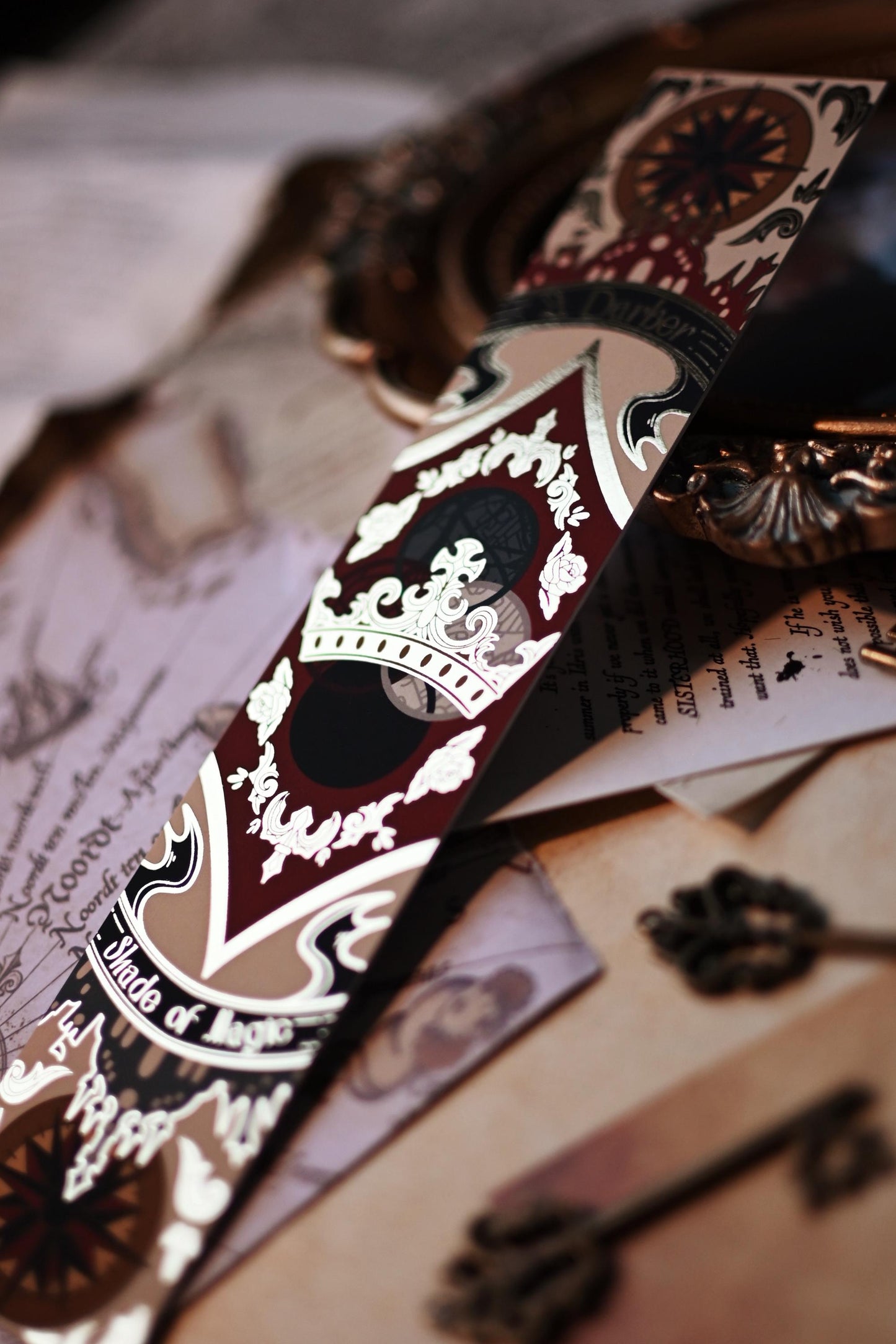A close up of the No0neDesigns gold foil detailing featuring a crown inspired by A Darker Shade of Magic by V.E Schwab.