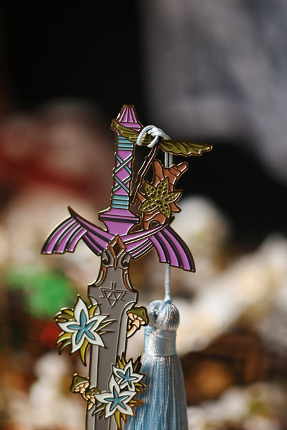No0neDesigns Link's Master Sword enamel bookmark close up picture focusing on the hilt of the bookmark and tassel.