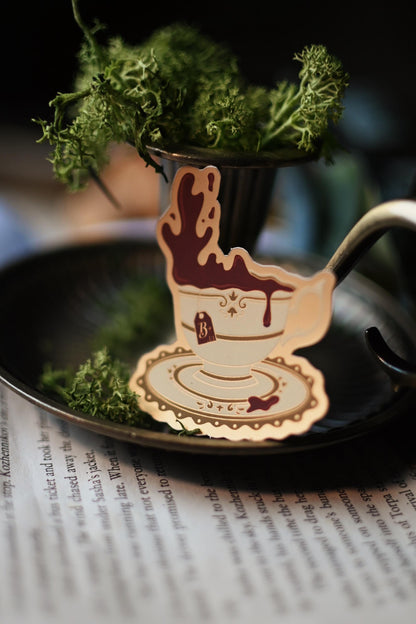 Tea With A Vampire sticker designed by No0neDesigns and inspired by Interview with a vampire propped up against a candle holder to showcase the tea sticker design. 