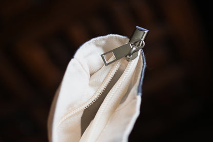 Close-up of a white jacket with a zipper on a dark background