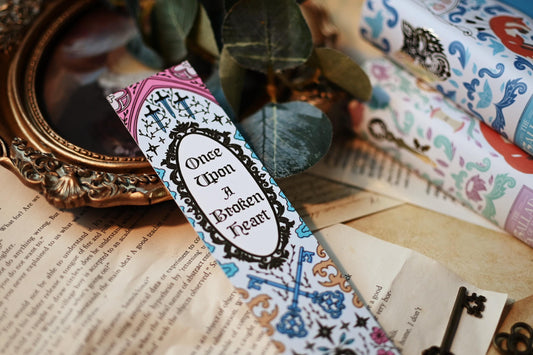 Inspired by the books by Stephanie Garbar, the Once Upon a Broken Heart bookspine bookmark rests against a background of the books, bookpages and propped up by a mirror. 