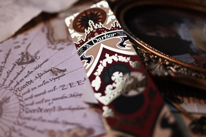 A side close up of the A Darker Shade of Magic book spine bookmark inspired by the work by V.E Schwab and close up detailing of the gold foil against the light. 