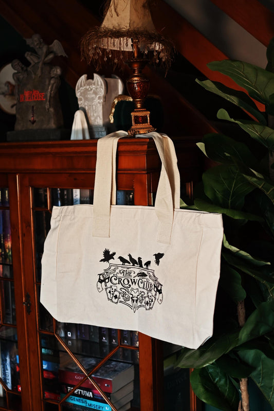 No One Designs The Crow Club inspired book bag from the world of Six of Crows by Leigh Bardugo. The photo showcases the extra large tote bag with the embroided print of the crow club logo. 